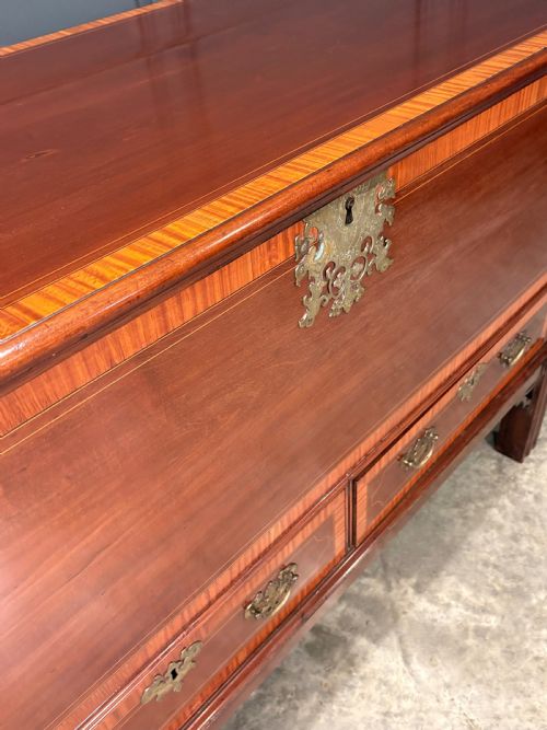 fig 3. A Georgian inlaid mahogany silver chest on stand featuring satinwood crossbanding, brass side carrying handles, two lower drawers, and square legs with bracket corner supports.