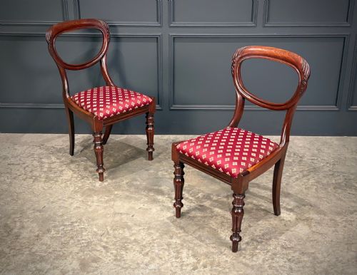 fig 1. A pair of Victorian mahogany side chairs with rounded balloon backs, turned front legs, and red patterned fabric seats.
