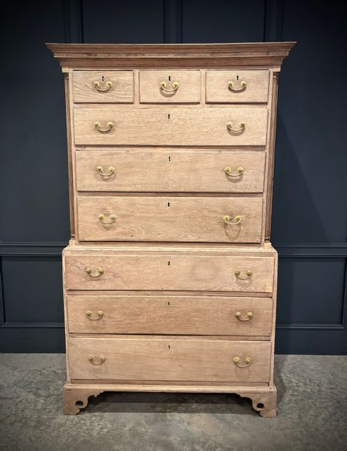 fig 1. A Georgian bleached oak chest on chest featuring a two-part stacked design with brass drop handles and bracket feet.