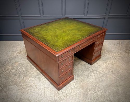 fig 1. A large Victorian mahogany partners desk with a green leather inset top surface and twin pedestals fitted with wooden drawer pulls.