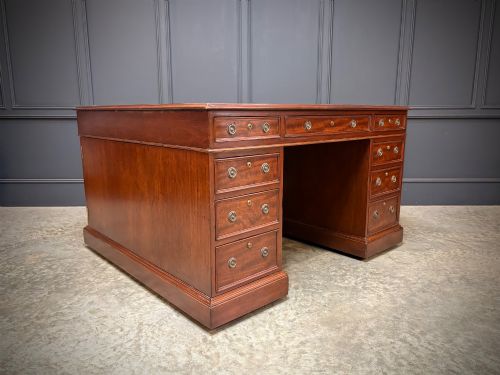fig 2. A large Victorian mahogany partners desk with a green leather inset top surface and twin pedestals fitted with wooden drawer pulls.