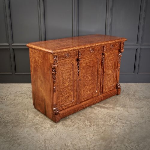 fig 1. A 19th-century Victorian pollard oak sideboard featuring three relief-panelled cupboard doors, carved corbels, and a figure-rich timber surface.