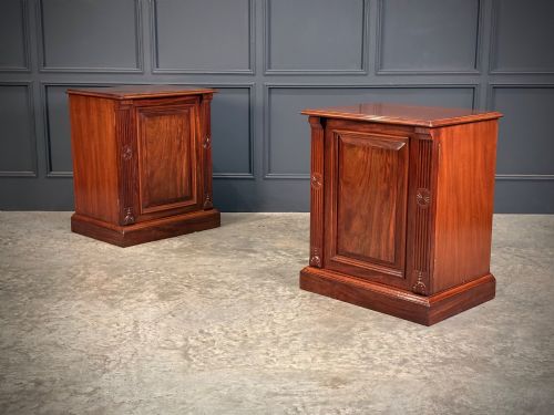 fig 1. A matching pair of Victorian mahogany bedside cabinets featuring panelled doors with flame veneer and carved fluted pilasters on plinth bases.