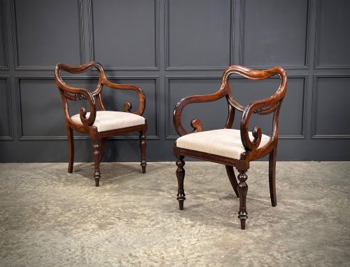 fig 1. A set of eight Victorian rosewood dining chairs with balloon backs, carved details, scroll armrests, and neutral beige seats.