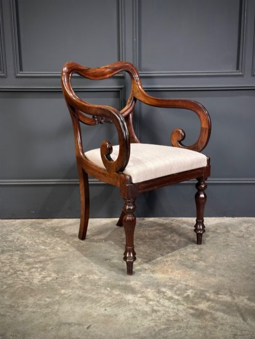 fig 2. A set of eight Victorian rosewood dining chairs with balloon backs, carved details, scroll armrests, and neutral beige seats.