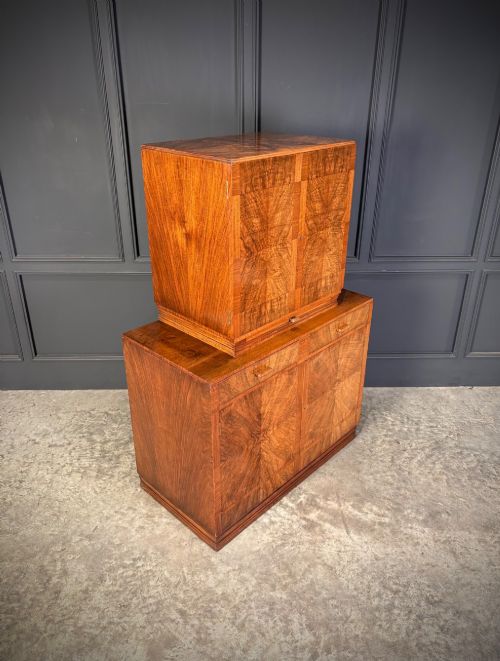 fig 1. An Art Deco two-tiered cocktail cabinet in figured walnut veneer featuring double doors and geometric paneling.