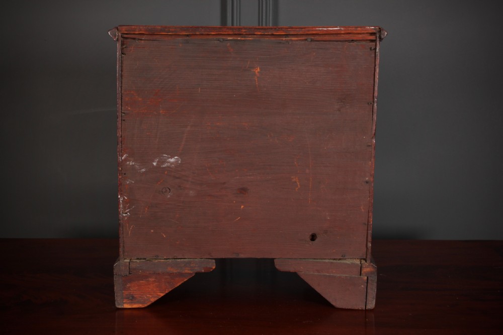 A Georgian style miniature mahogany chest of drawers with two short drawers over three long graduated drawers, turned knobs, and bracket feet. View IX