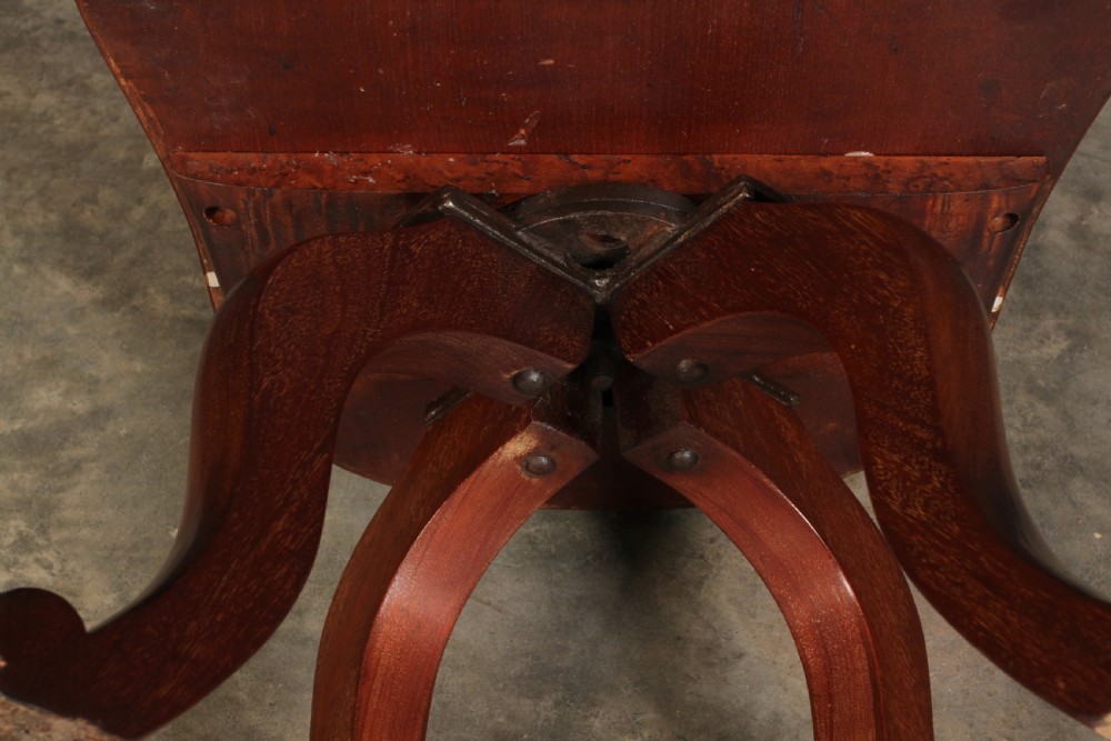 A Victorian mahogany swivel desk chair featuring a curved backrest with a carved central splat, shaped armrests, a solid saddled seat, and four splayed cabriole legs. View XI