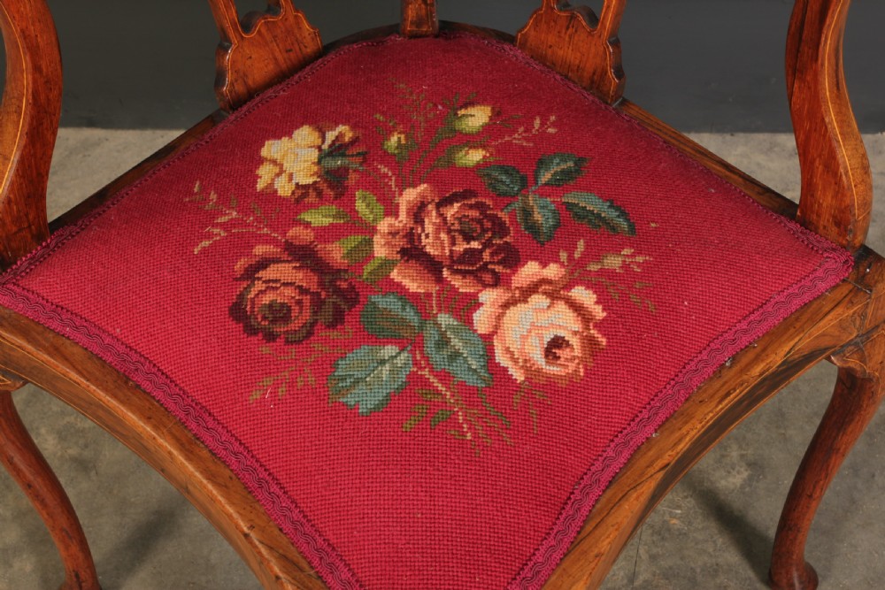 An antique rosewood corner chair featuring floral marquetry inlays on the curved top rail and splats, supported by cabriole legs and upholstered in red floral needlepoint. View VII