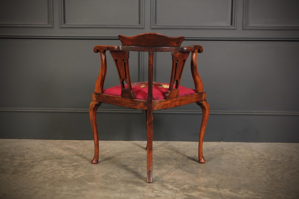 An antique rosewood corner chair featuring floral marquetry inlays on the curved top rail and splats, supported by cabriole legs and upholstered in red floral needlepoint. View XI
