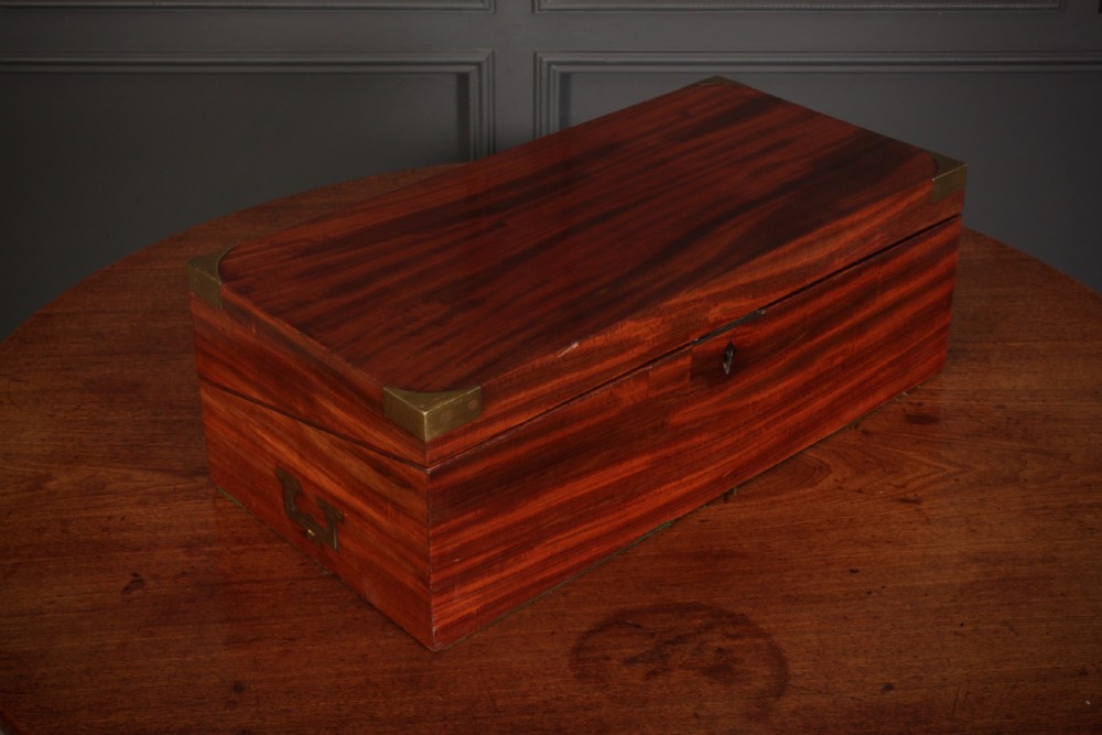 A closed rectangular Victorian mahogany writing slope with brass corner mounts and side carrying handles on a polished wooden surface. View III