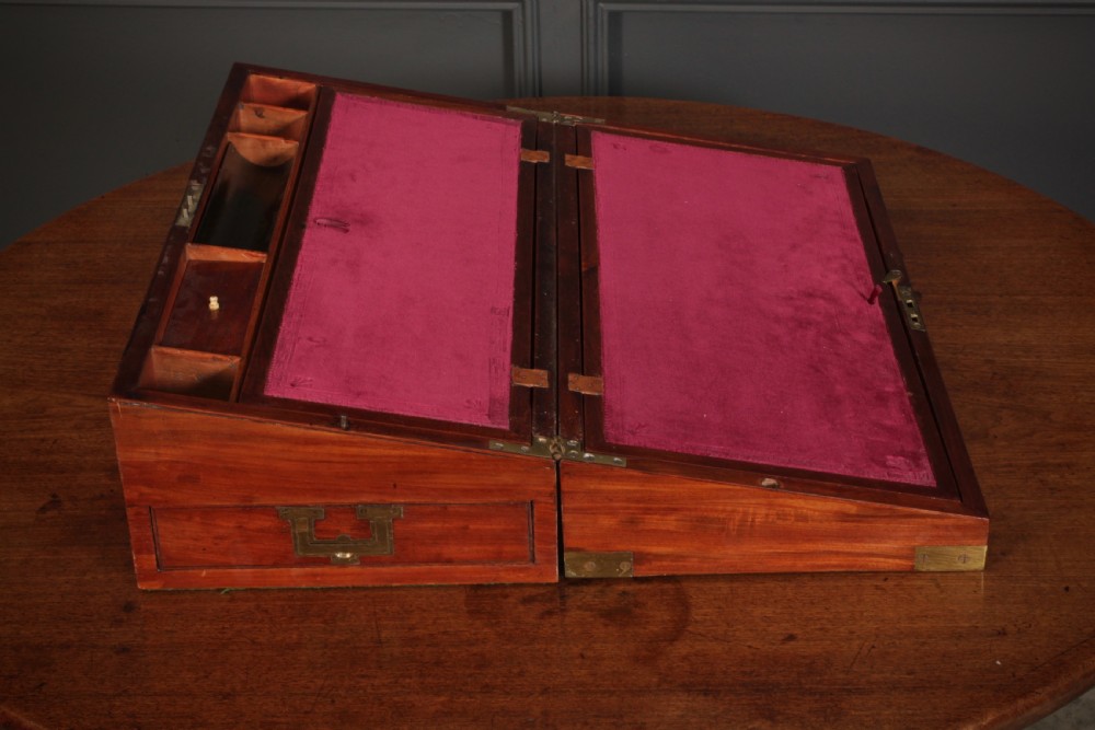 A closed rectangular Victorian mahogany writing slope with brass corner mounts and side carrying handles on a polished wooden surface. View VII