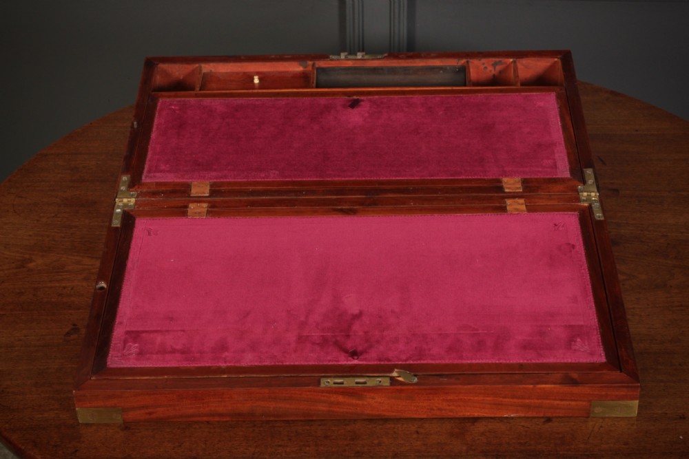 A closed rectangular Victorian mahogany writing slope with brass corner mounts and side carrying handles on a polished wooden surface. View VIII