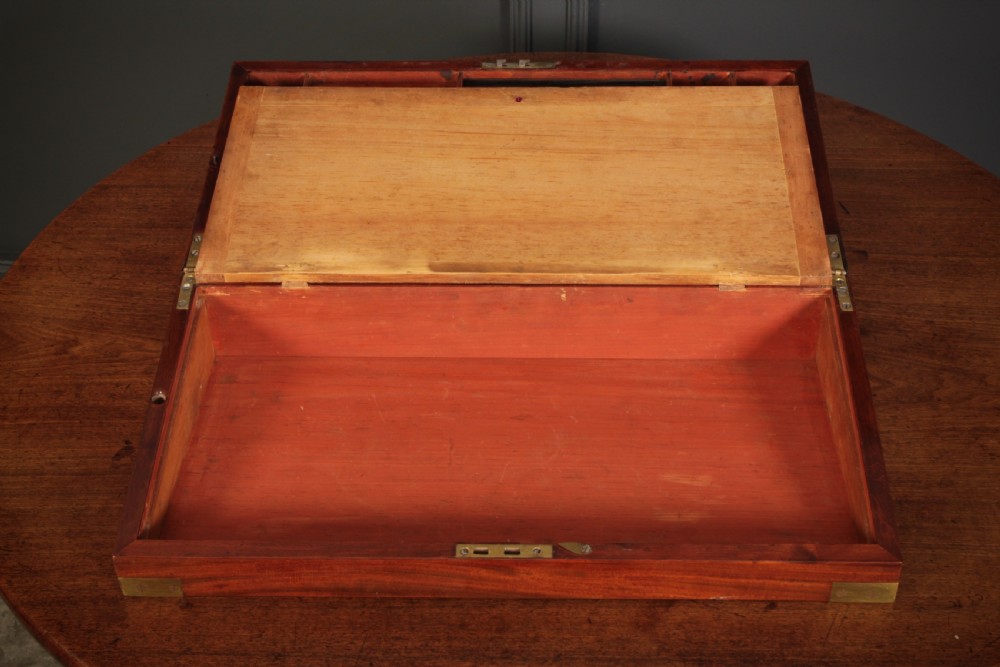 A closed rectangular Victorian mahogany writing slope with brass corner mounts and side carrying handles on a polished wooden surface. View IX