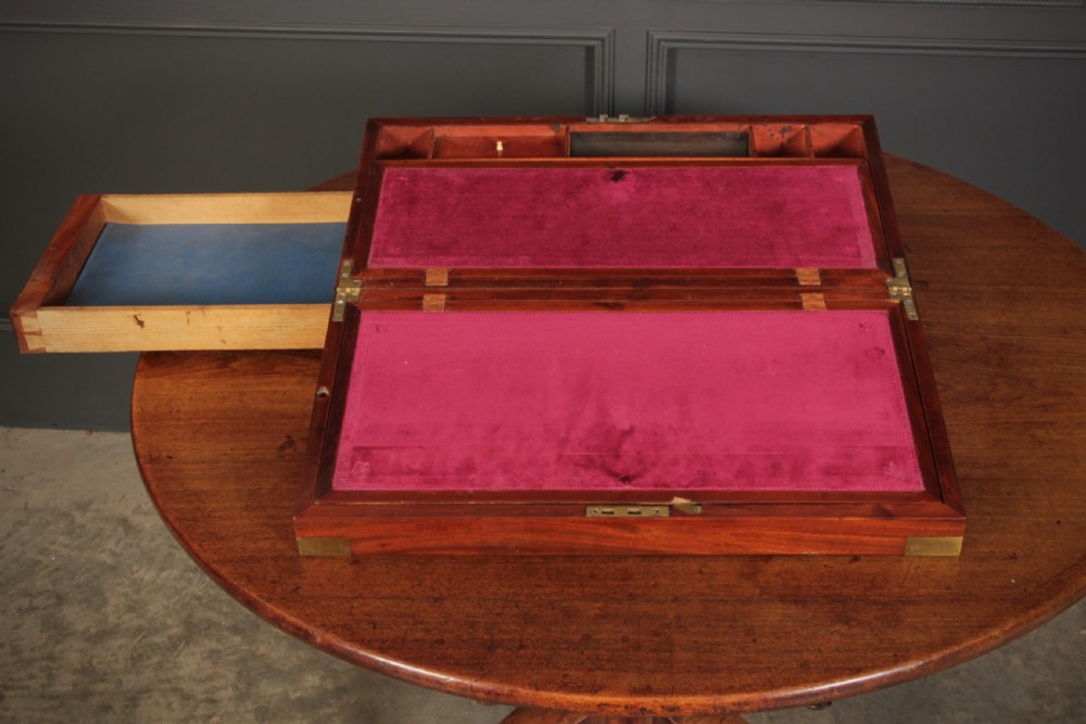 A closed rectangular Victorian mahogany writing slope with brass corner mounts and side carrying handles on a polished wooden surface. View X