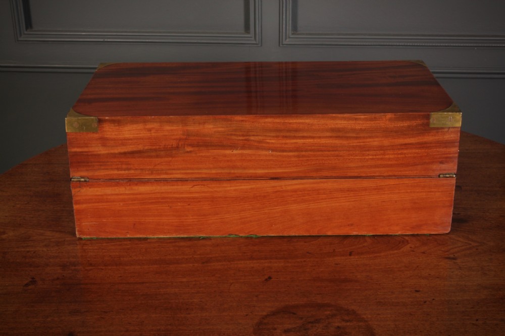 A closed rectangular Victorian mahogany writing slope with brass corner mounts and side carrying handles on a polished wooden surface. View XII