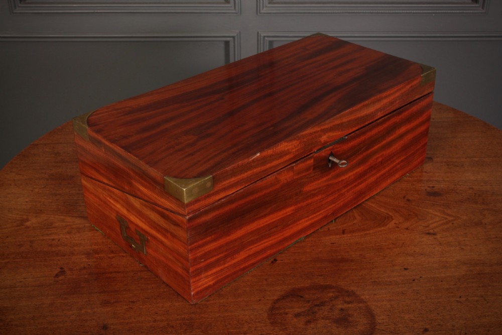 A closed rectangular Victorian mahogany writing slope with brass corner mounts and side carrying handles on a polished wooden surface. View XIV