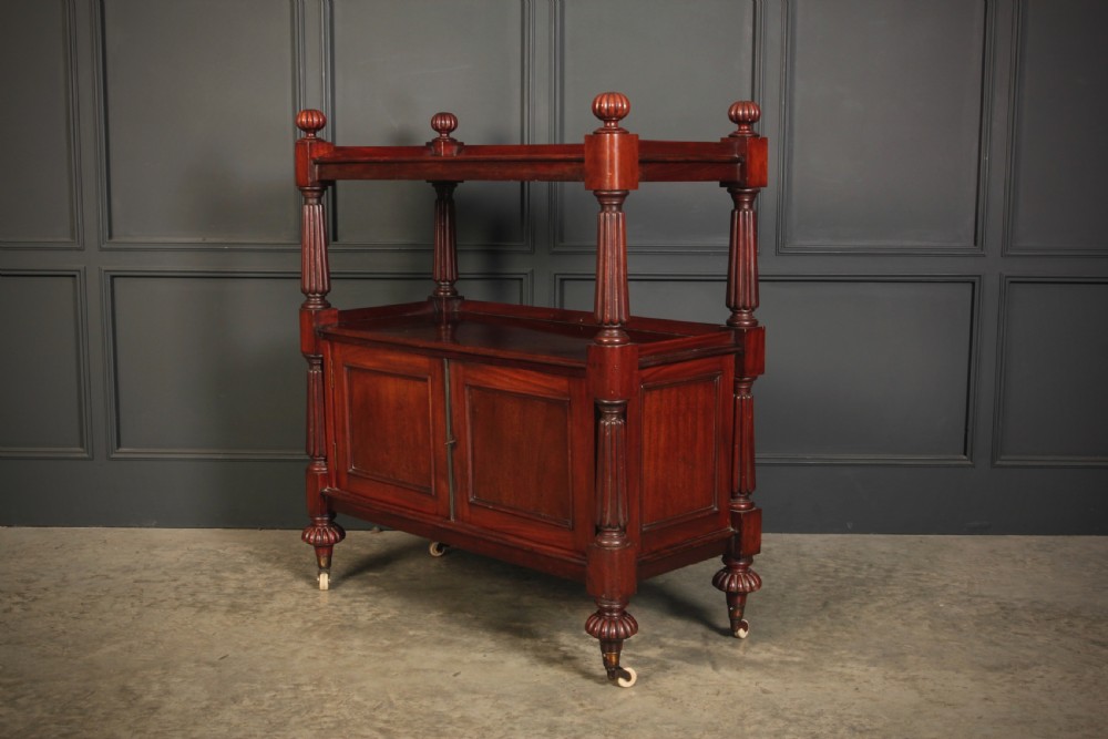 A Victorian mahogany two-tier buffet cabinet featuring turned reeded columns, a lower panelled cupboard, finials, and white castors. View VI