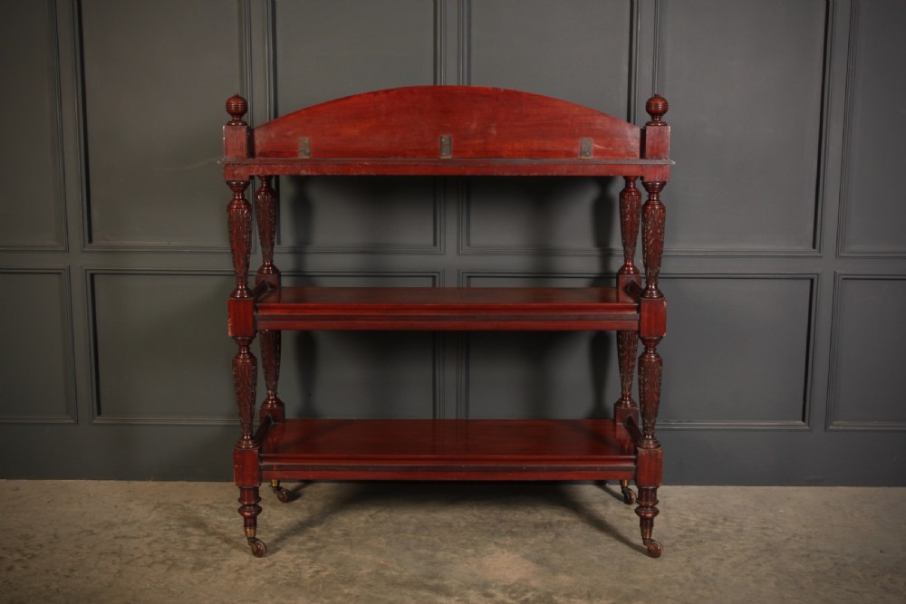 A Victorian mahogany three-tier buffet featuring carved turned column supports, a scrolled decorative backboard, and brass castors. View VIII