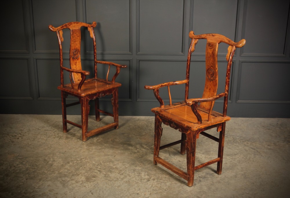 A pair of antique Chinese elm wood armchairs featuring curved yoke-back top rails, carved central back splats, and a warm honey-brown finish. View II