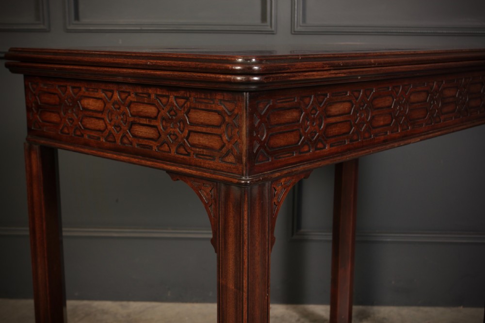 A dark mahogany fold-over card table in the Chinese Chippendale style featuring blind fretwork carved along the frieze and fluted square legs. View III