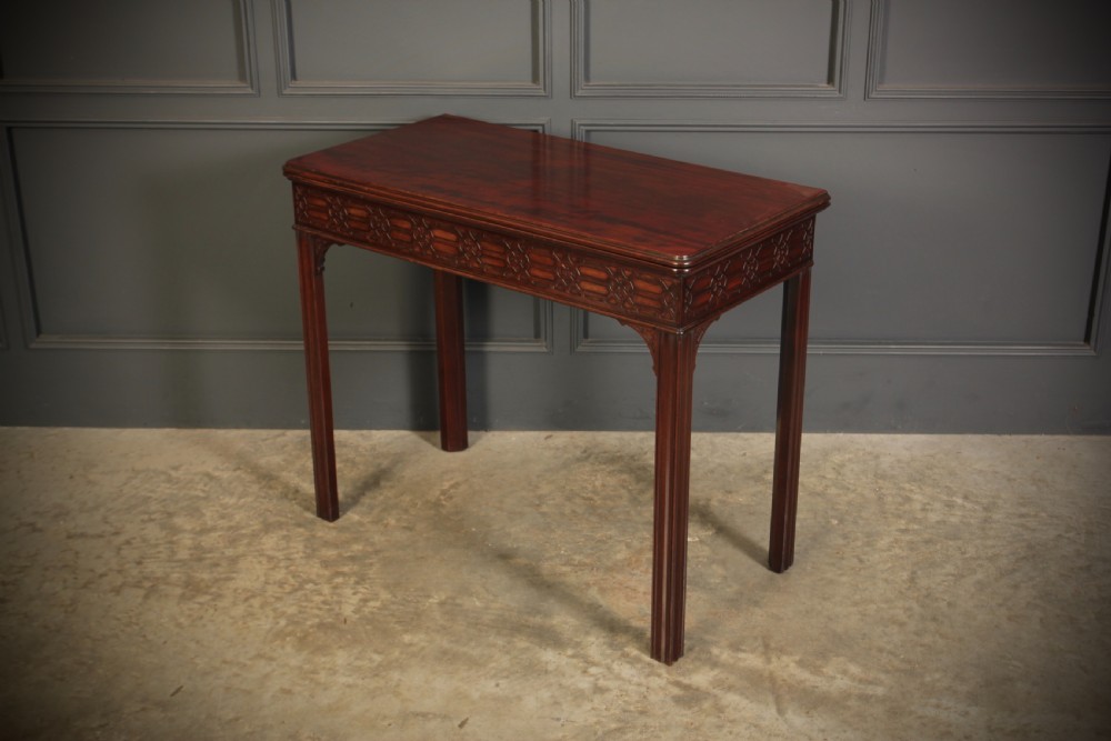 A dark mahogany fold-over card table in the Chinese Chippendale style featuring blind fretwork carved along the frieze and fluted square legs. View VII