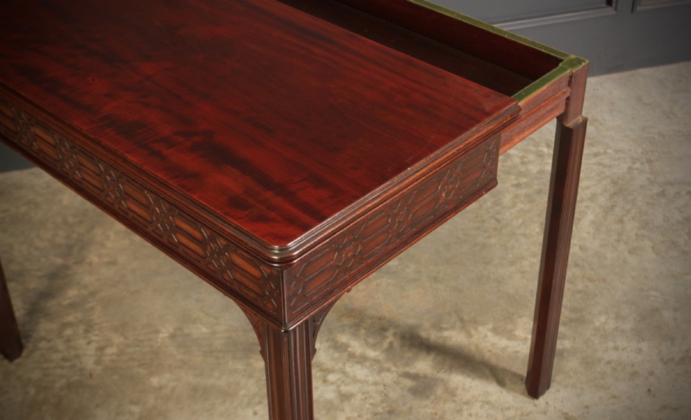 A dark mahogany fold-over card table in the Chinese Chippendale style featuring blind fretwork carved along the frieze and fluted square legs. View XI