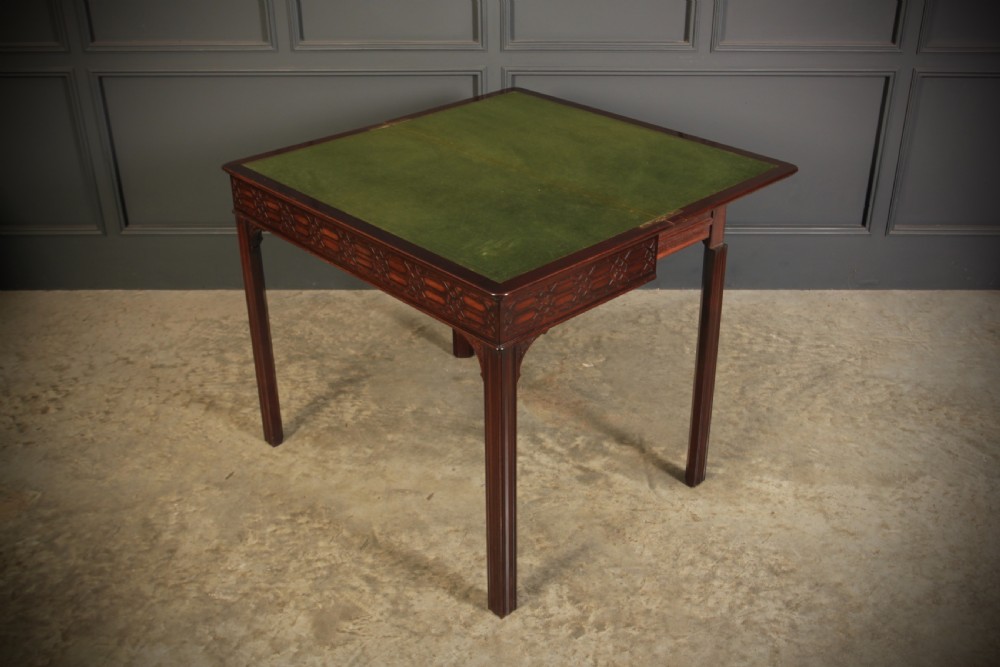 A dark mahogany fold-over card table in the Chinese Chippendale style featuring blind fretwork carved along the frieze and fluted square legs. View XII