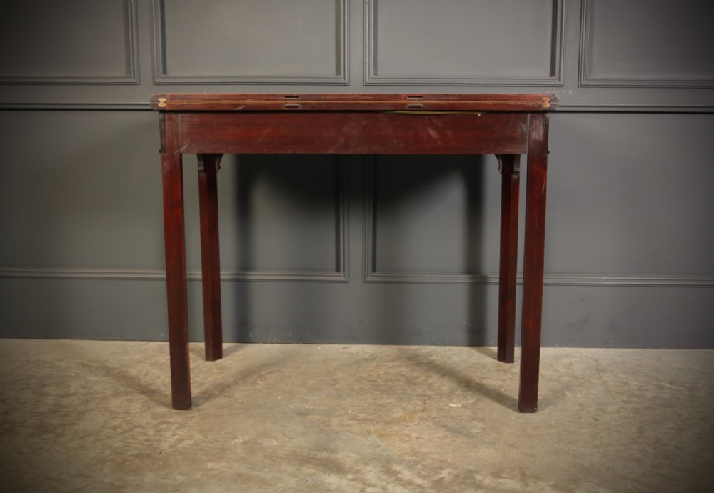 A dark mahogany fold-over card table in the Chinese Chippendale style featuring blind fretwork carved along the frieze and fluted square legs. View XIV