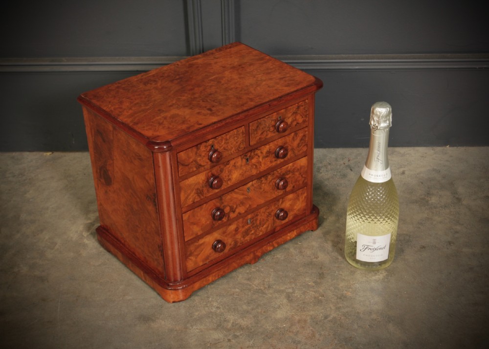 A miniature burr walnut chest of drawers featuring two short drawers above three long graduated drawers with turned wooden knob handles. View II