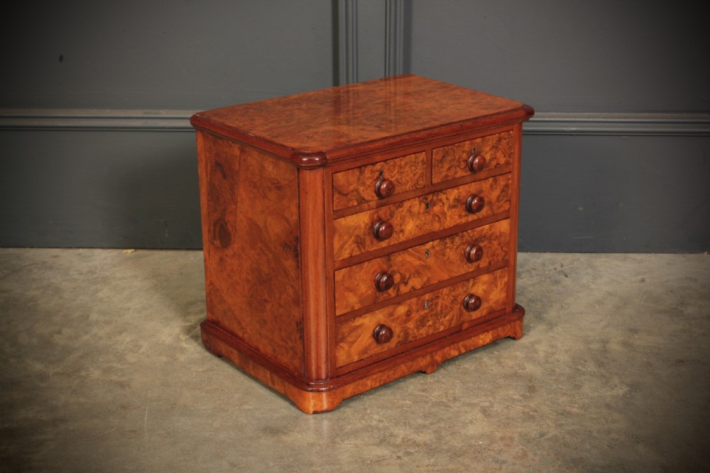 A miniature burr walnut chest of drawers featuring two short drawers above three long graduated drawers with turned wooden knob handles. View III
