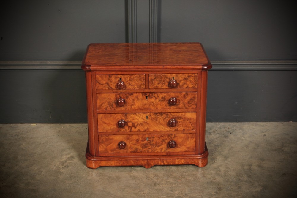A miniature burr walnut chest of drawers featuring two short drawers above three long graduated drawers with turned wooden knob handles. View IV