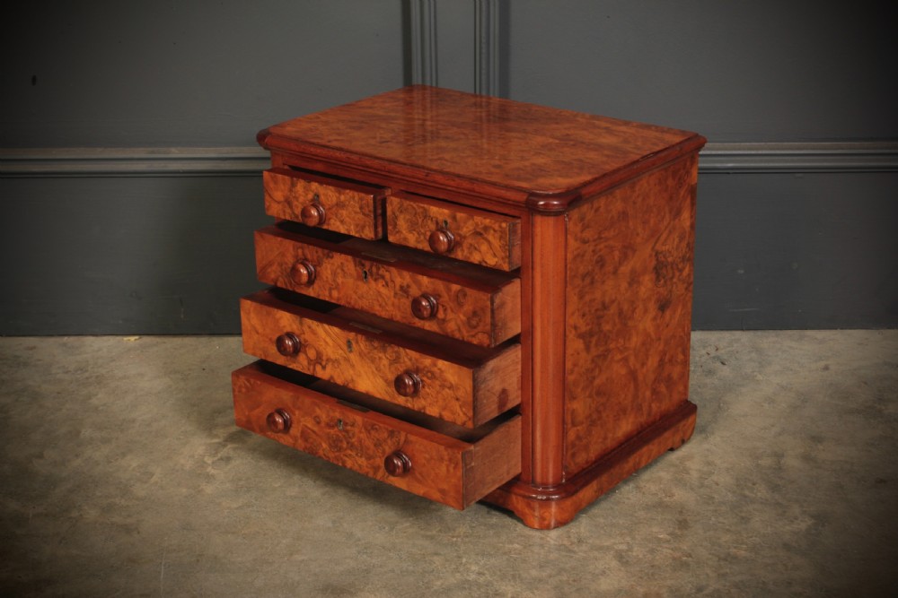 A miniature burr walnut chest of drawers featuring two short drawers above three long graduated drawers with turned wooden knob handles. View VI