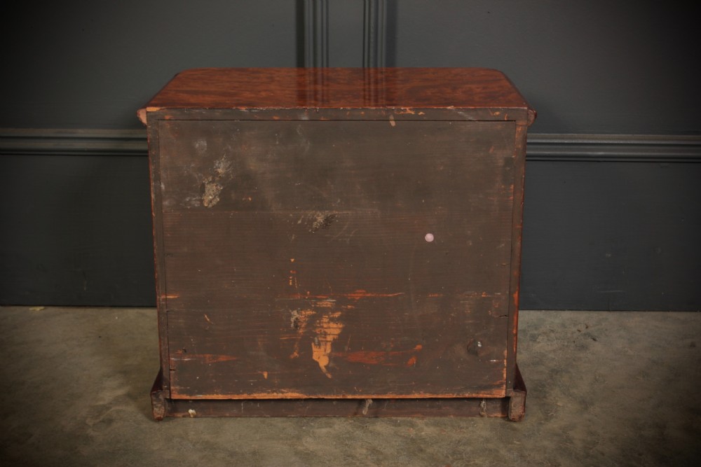 A miniature burr walnut chest of drawers featuring two short drawers above three long graduated drawers with turned wooden knob handles. View IX