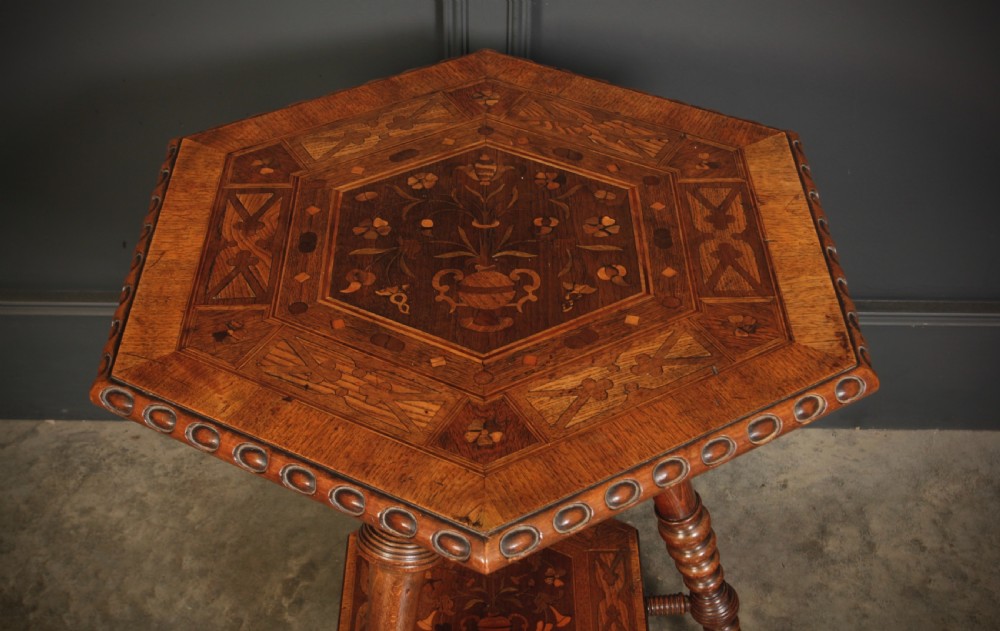 A Victorian hexagonal walnut occasional table featuring floral marquetry inlays, a carved edge, a lower tier, and turned legs. View II