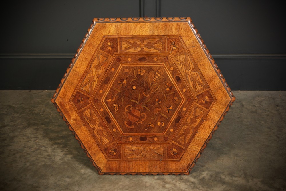 A Victorian hexagonal walnut occasional table featuring floral marquetry inlays, a carved edge, a lower tier, and turned legs. View VIII