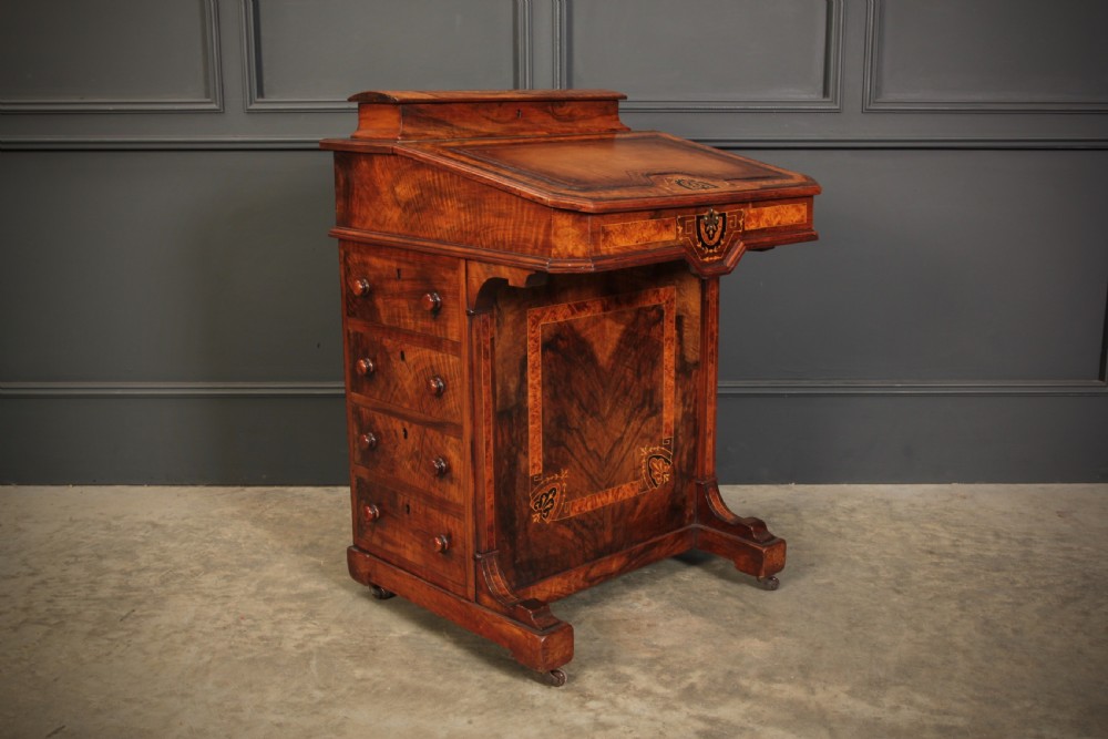 A Victorian figured walnut Davenport desk featuring a sloped leather writing top, intricate marquetry inlays, and a side bank of four drawers with turned wooden handles. View II