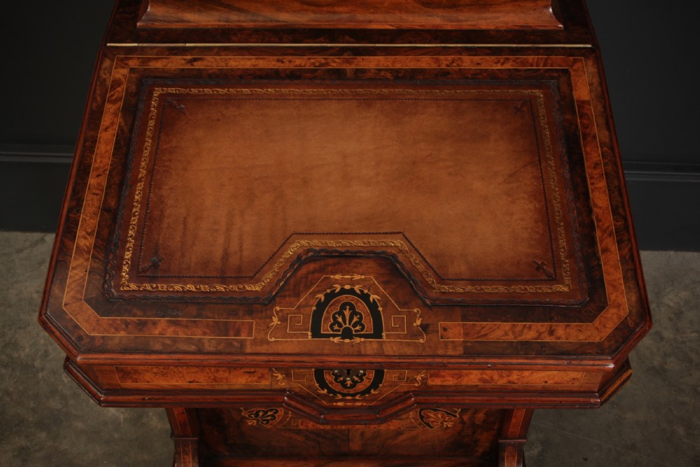 A Victorian figured walnut Davenport desk featuring a sloped leather writing top, intricate marquetry inlays, and a side bank of four drawers with turned wooden handles. View X