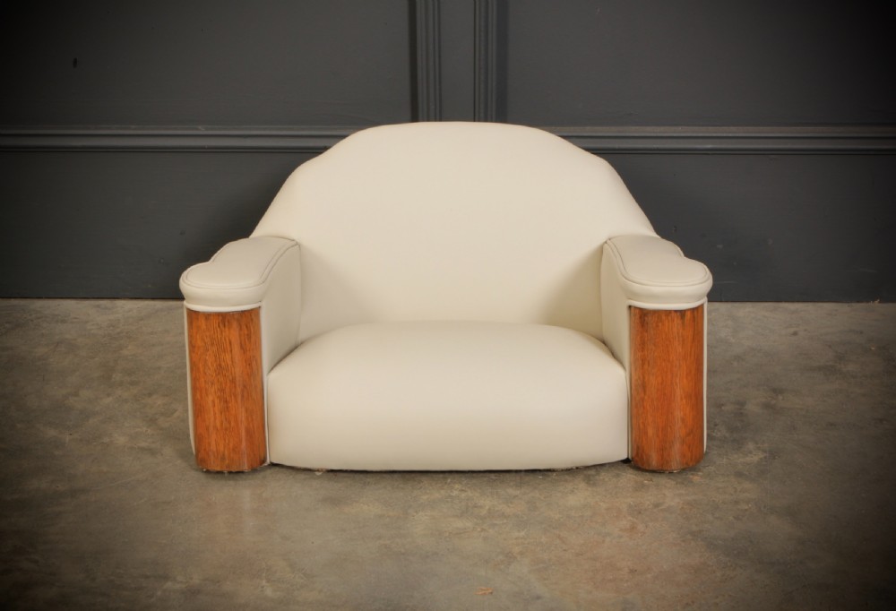 A miniature Art Deco three-piece suite featuring a small sofa and two matching armchairs upholstered in cream leather with polished curved wood arm fronts. View IV