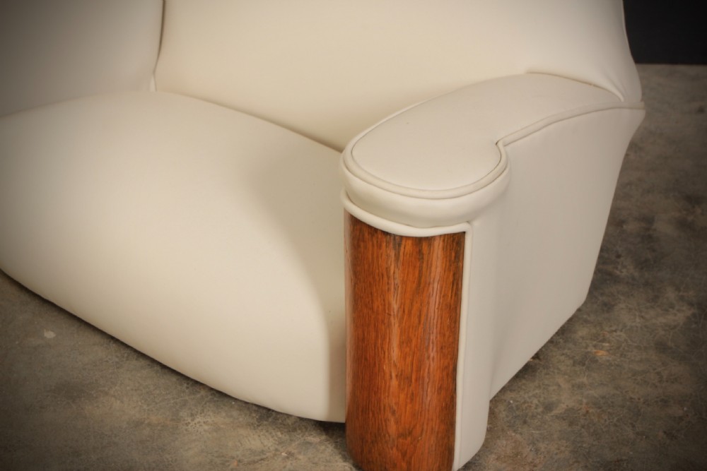 A miniature Art Deco three-piece suite featuring a small sofa and two matching armchairs upholstered in cream leather with polished curved wood arm fronts. View VI