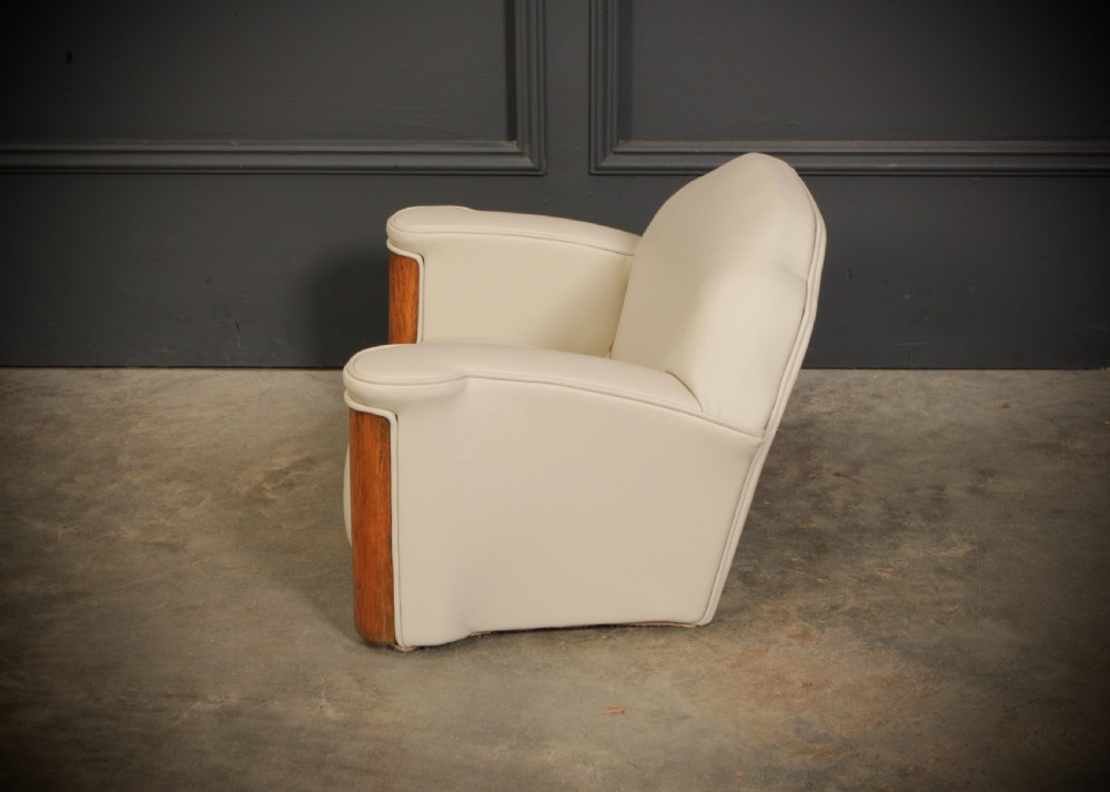 A miniature Art Deco three-piece suite featuring a small sofa and two matching armchairs upholstered in cream leather with polished curved wood arm fronts. View VII