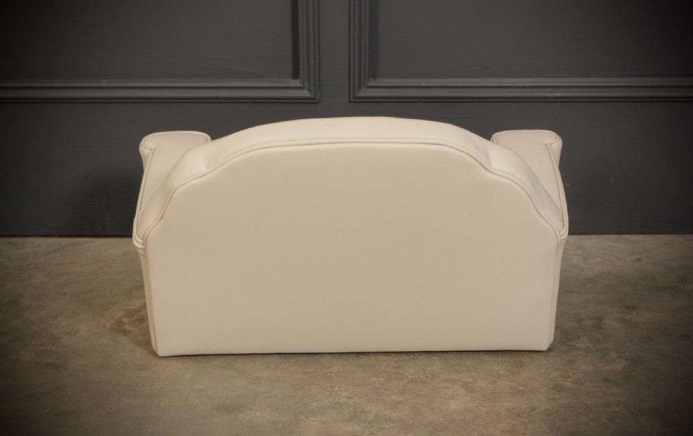 A miniature Art Deco three-piece suite featuring a small sofa and two matching armchairs upholstered in cream leather with polished curved wood arm fronts. View VIII