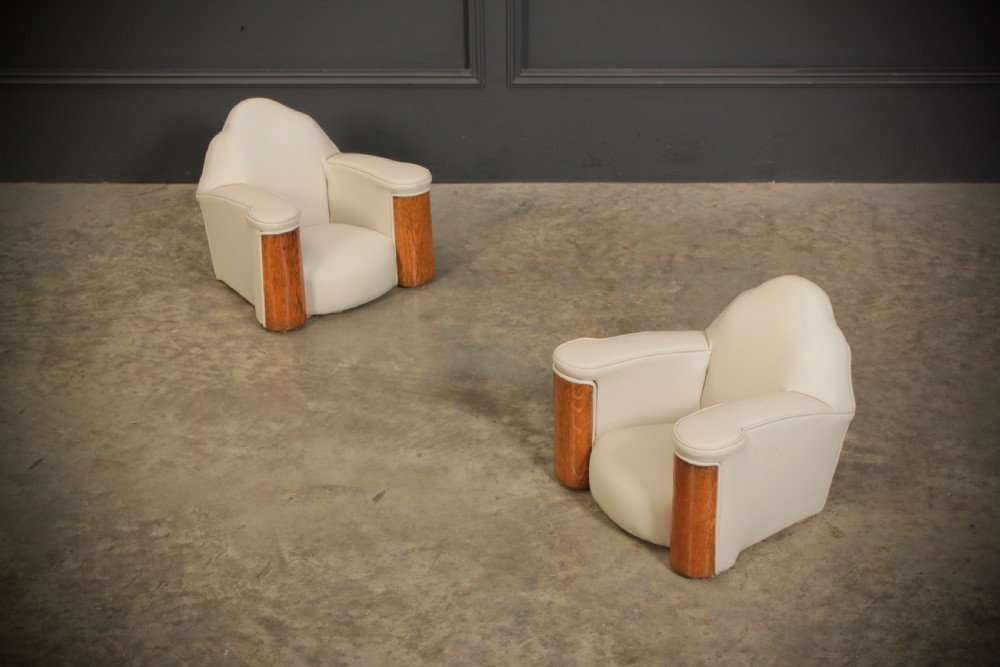 A miniature Art Deco three-piece suite featuring a small sofa and two matching armchairs upholstered in cream leather with polished curved wood arm fronts. View X