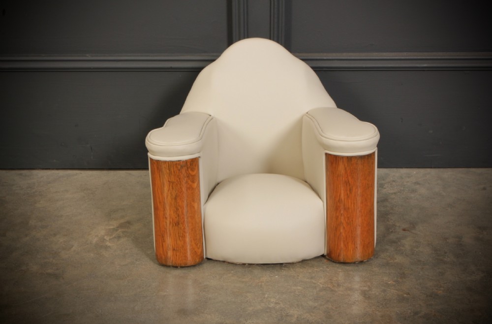A miniature Art Deco three-piece suite featuring a small sofa and two matching armchairs upholstered in cream leather with polished curved wood arm fronts. View XV