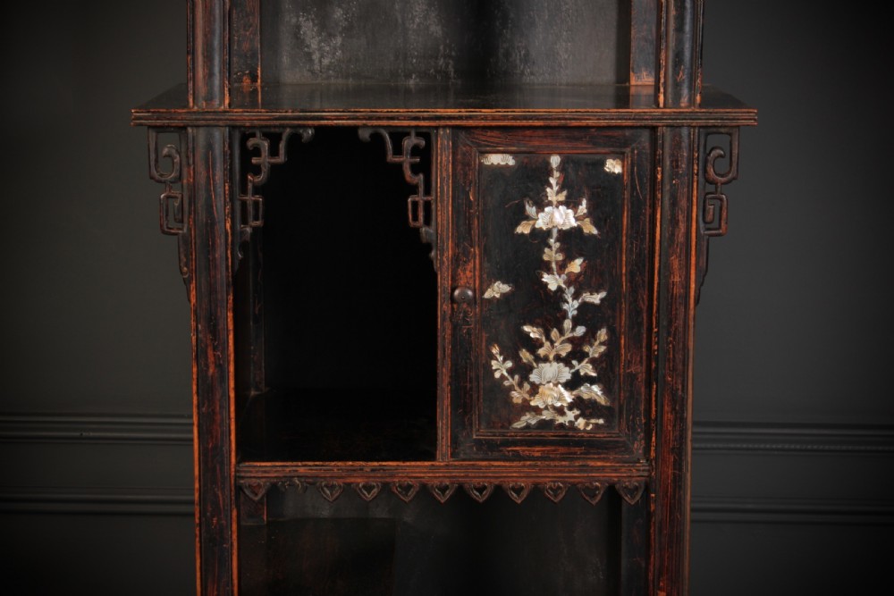 A tall, narrow antique Chinese dark wood floor clock featuring asymmetrical tiered display shelves, intricate carved fretwork, mother-of-pearl inlay details, and a pagoda-style bonnet top housing a circular clock face. View III
