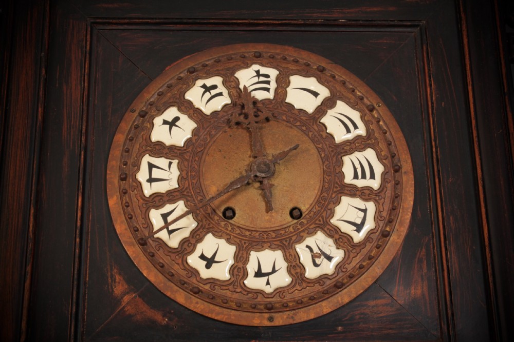 A tall, narrow antique Chinese dark wood floor clock featuring asymmetrical tiered display shelves, intricate carved fretwork, mother-of-pearl inlay details, and a pagoda-style bonnet top housing a circular clock face. View V