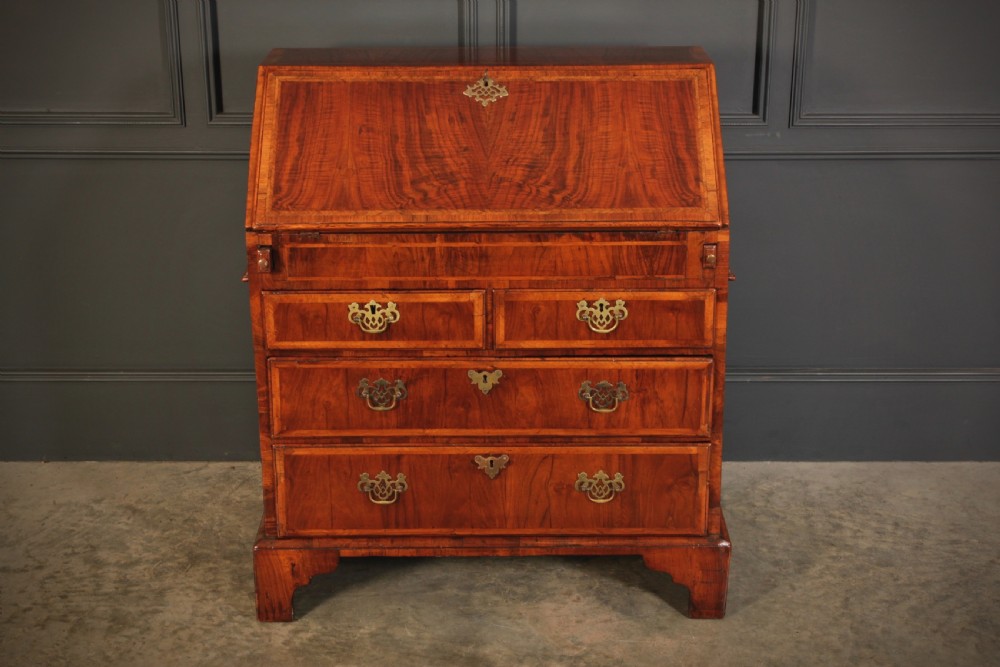 An eighteenth-century Queen Anne walnut slant-front bureau featuring brass drop handles, multiple drawers, and bracket feet. View II