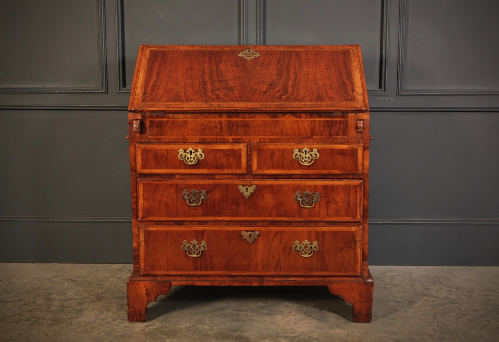 An eighteenth-century Queen Anne walnut slant-front bureau featuring brass drop handles, multiple drawers, and bracket feet. View III