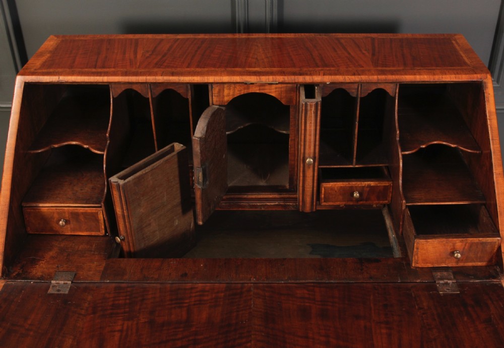 An eighteenth-century Queen Anne walnut slant-front bureau featuring brass drop handles, multiple drawers, and bracket feet. View VIII