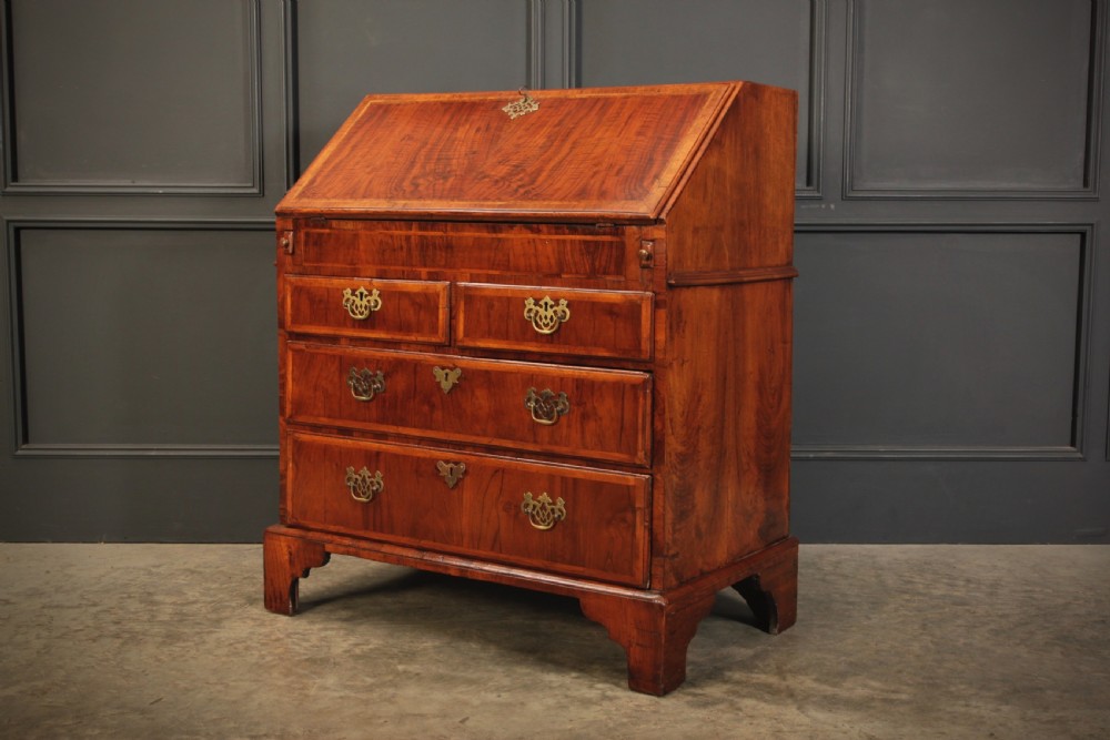 An eighteenth-century Queen Anne walnut slant-front bureau featuring brass drop handles, multiple drawers, and bracket feet. View XI